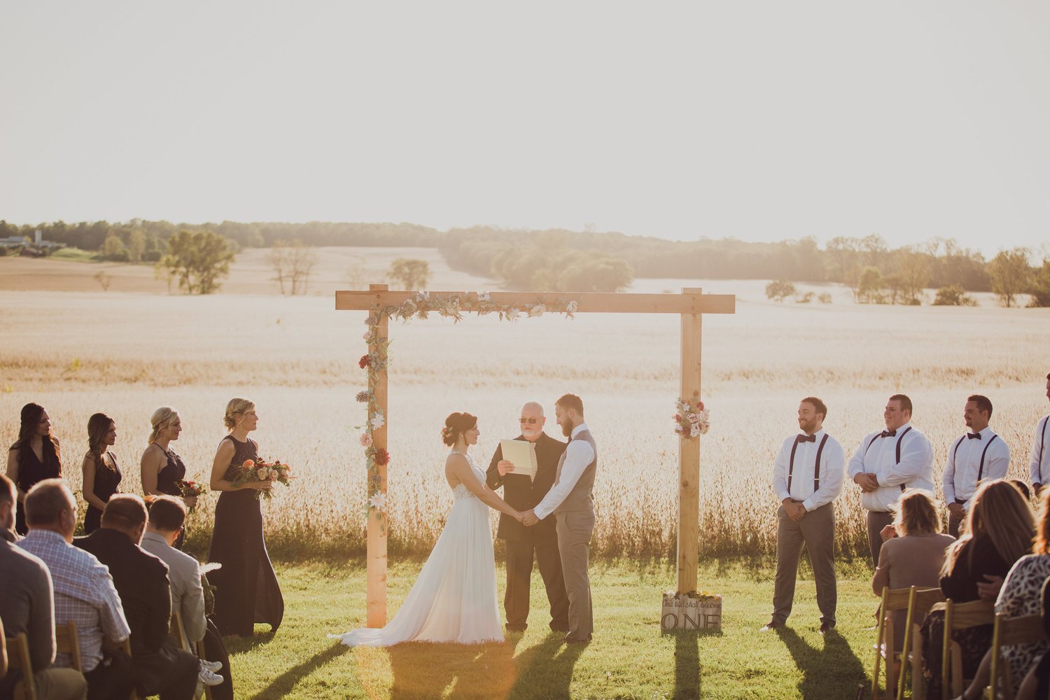 Open ceremony field at Wren Farm with white chairs facing rolling hills
