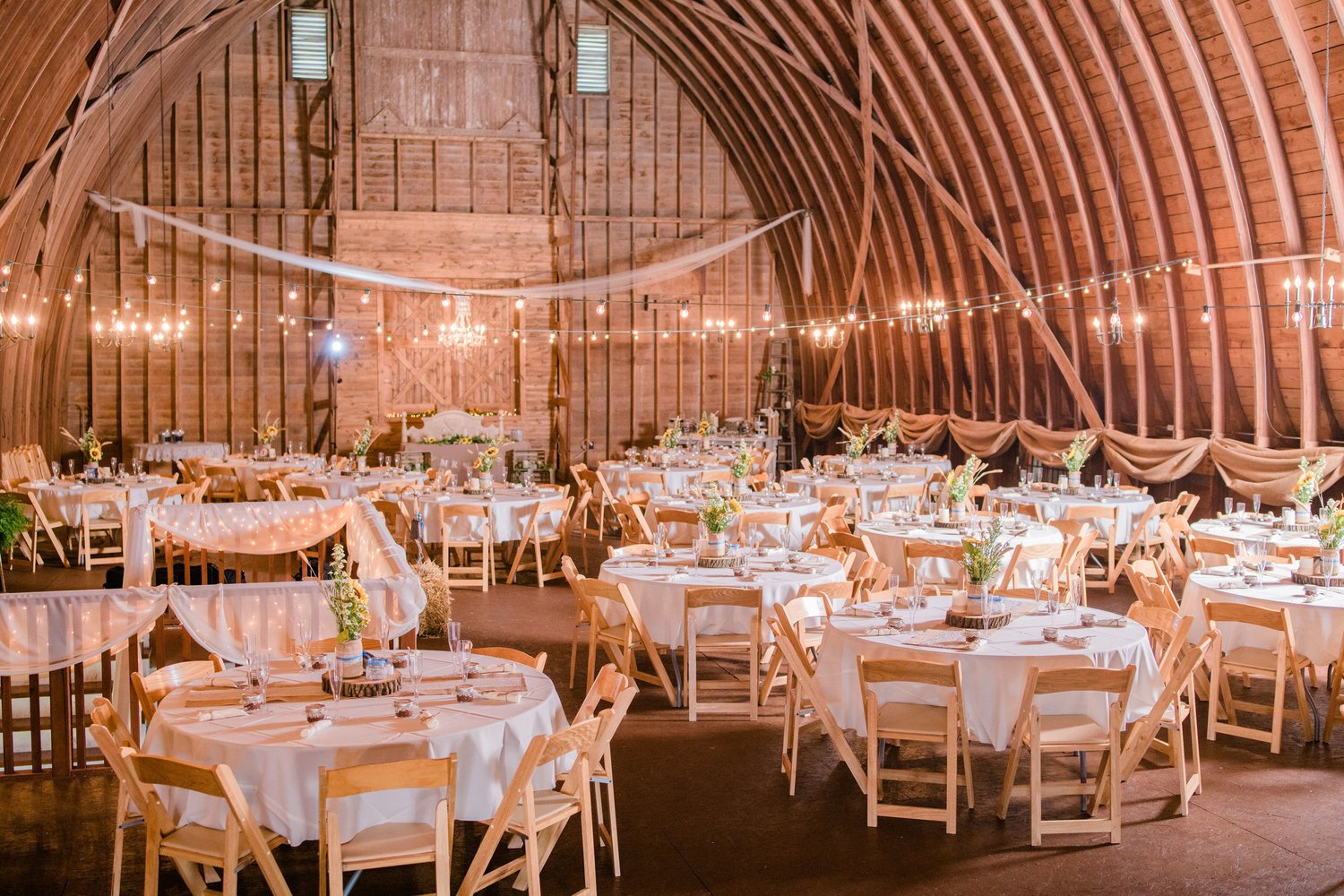 The historic Wren Farm barn at golden hour, framed by open countryside